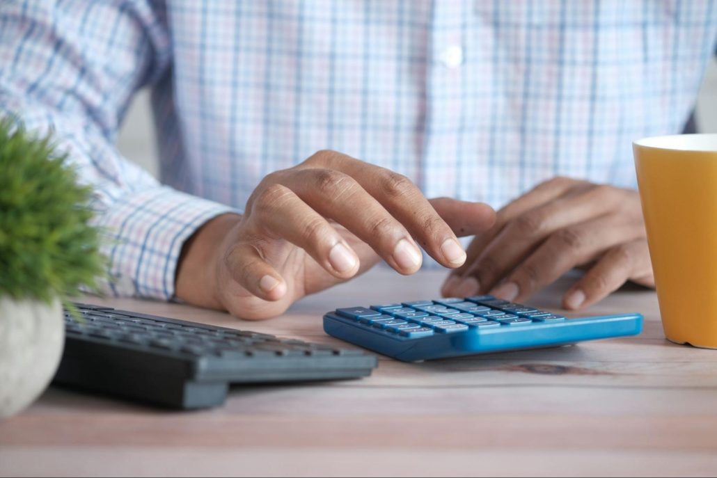 man using a calculator to create a budget