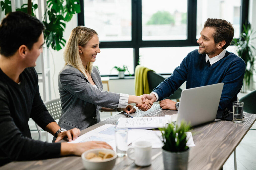 Young happy couple meeting with financial advisor in the office